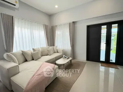 Modern living room with cozy sofa and large windows