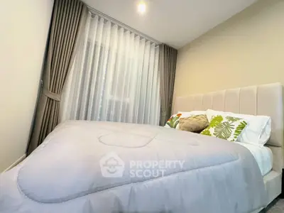 Cozy bedroom with elegant curtains and plush bedding in modern apartment