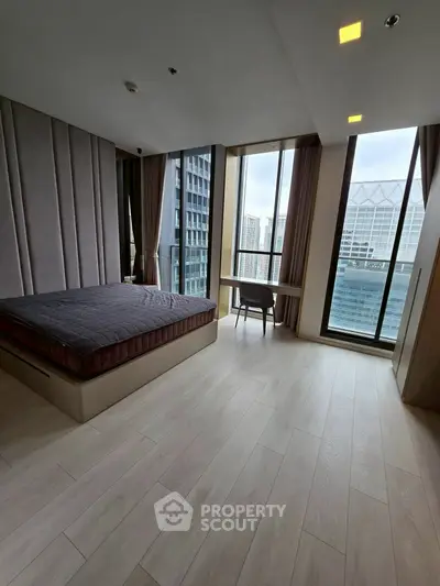 Spacious modern bedroom with floor-to-ceiling windows and city view