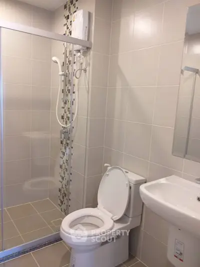 Modern bathroom with sleek shower and contemporary fixtures in a stylish real estate property.