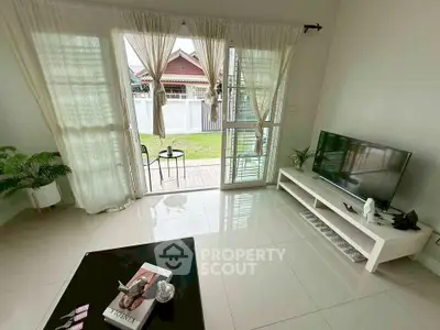 Bright living room with garden view, modern decor, and large windows.