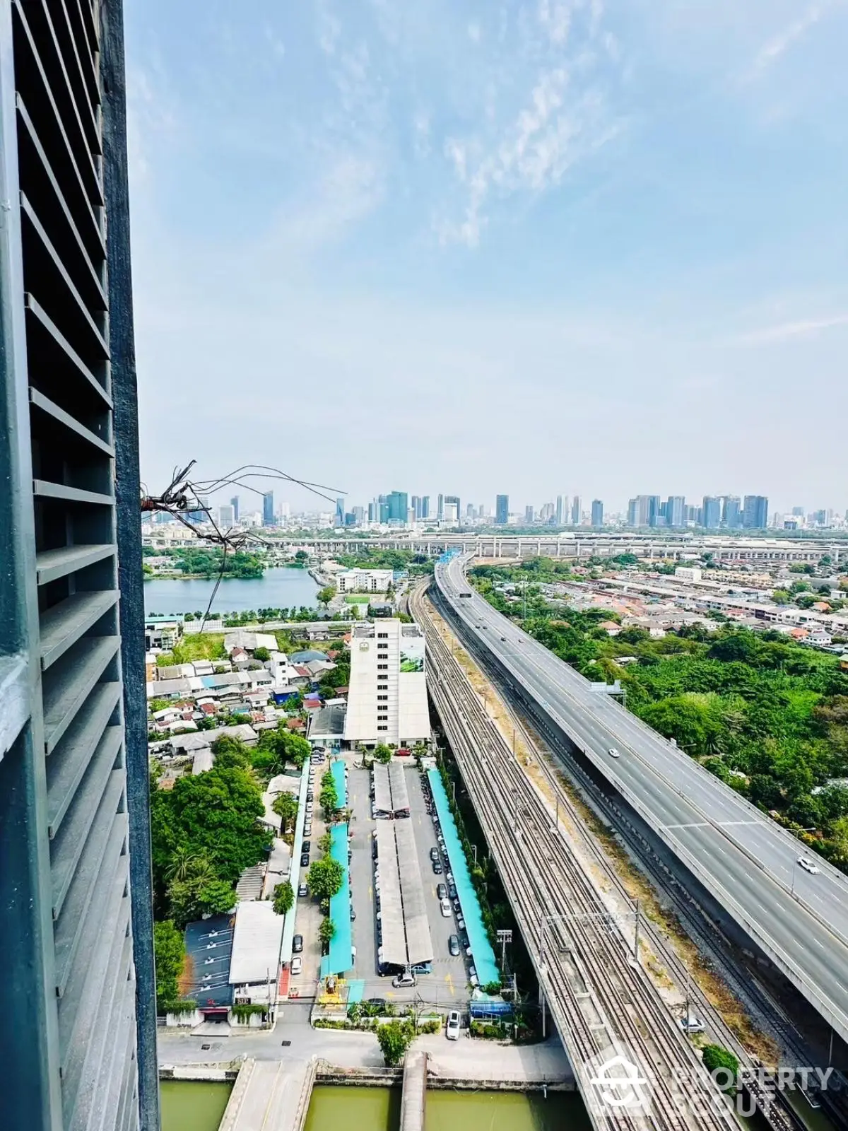 Stunning cityscape view from high-rise building overlooking highway and urban skyline.