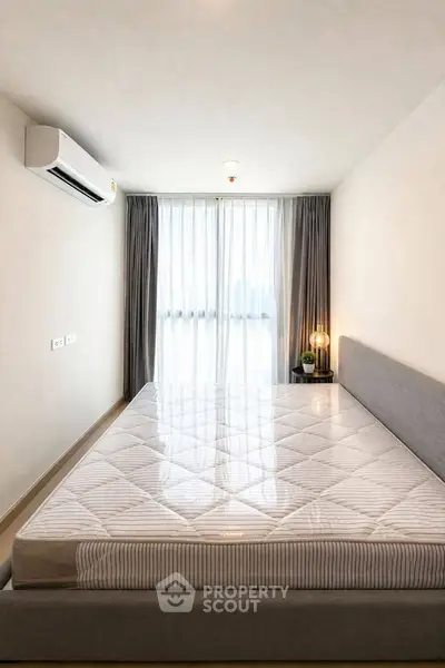 Modern bedroom with large window and air conditioning in a stylish apartment.