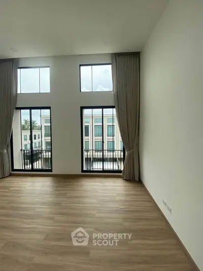 Spacious living room with high ceilings and large windows offering a bright and airy atmosphere.