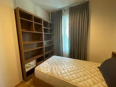Cozy bedroom with built-in shelves and large window, perfect for relaxation and storage.