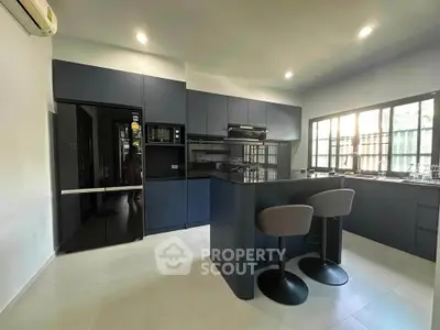 Modern kitchen with sleek black cabinets and breakfast bar seating