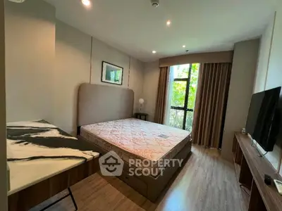 Spacious bedroom with large window and modern furnishings in a serene setting.