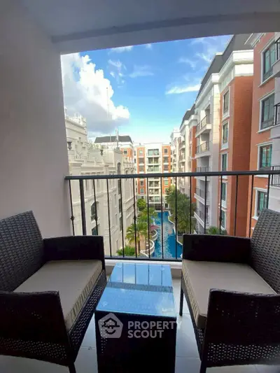 Charming balcony view overlooking a luxurious pool and elegant residential buildings.