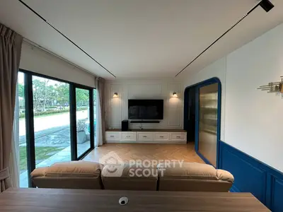Spacious living room with modern decor and large sliding glass doors opening to a scenic view.