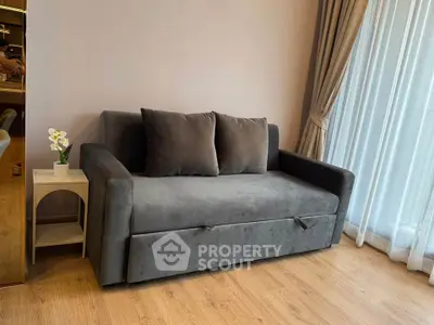 Modern living room with stylish gray sofa and elegant curtains, perfect for cozy relaxation.