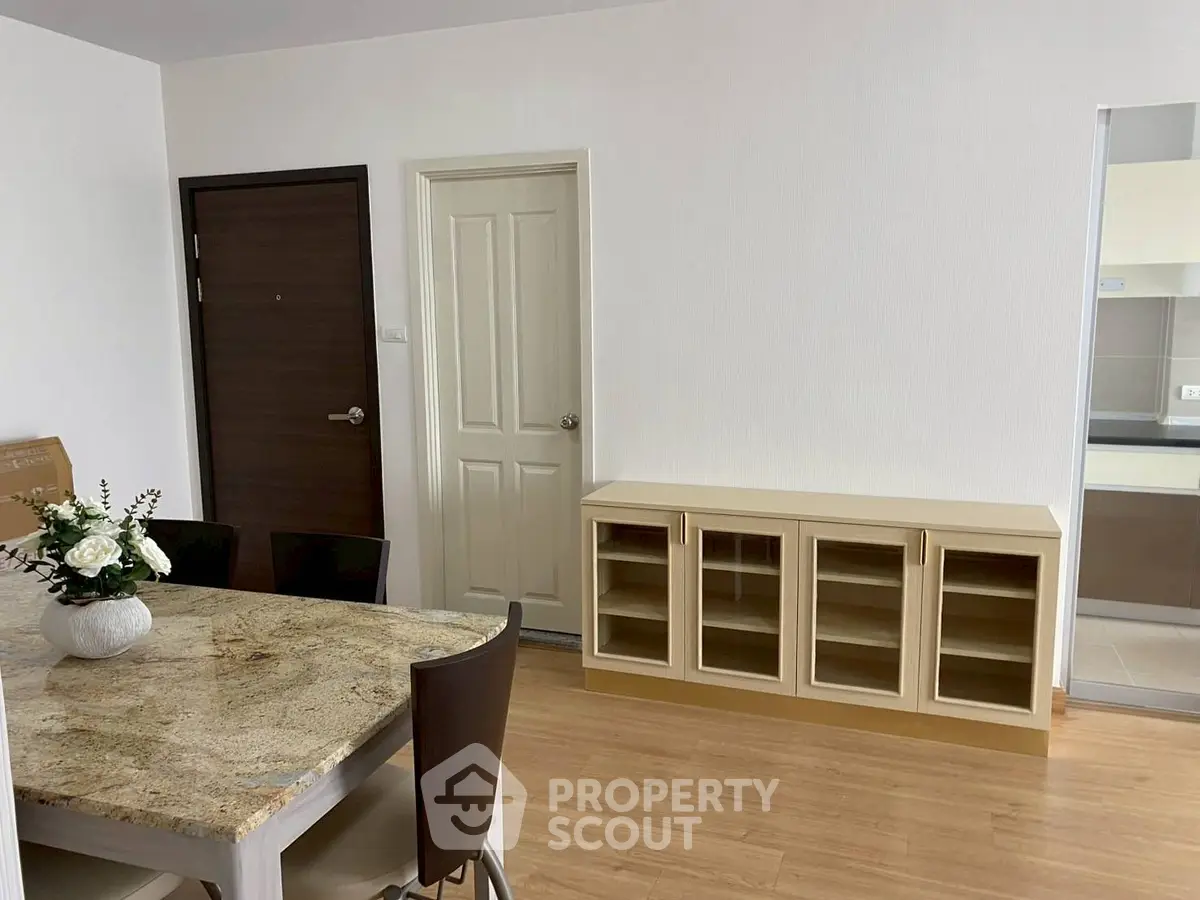 Modern dining area with elegant table and chairs, adjacent to a sleek kitchen space.