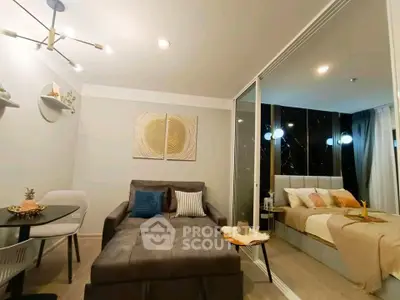 Modern living room with cozy sofa and elegant bedroom separated by glass partition