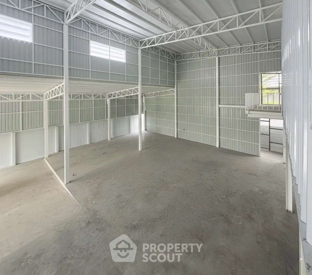 Spacious industrial warehouse with high ceilings and ample natural light.
