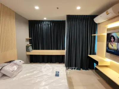 Modern bedroom with stylish decor and ambient lighting, featuring a cozy bed and sleek furnishings.