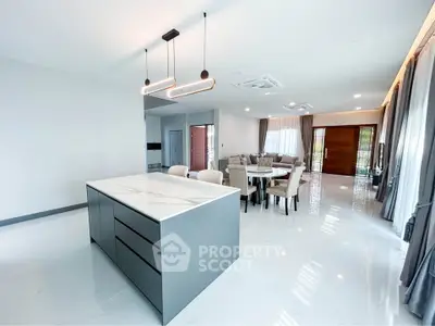 Spacious modern open-plan living and dining area with sleek kitchen island and elegant lighting.