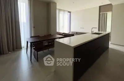 Spacious modern kitchen with island and dining area in elegant apartment.