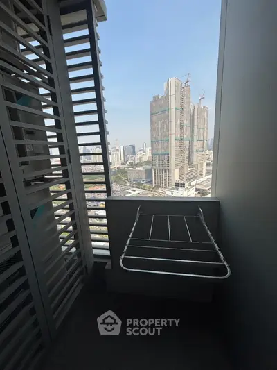High-rise balcony with city view and drying rack, perfect for urban living.