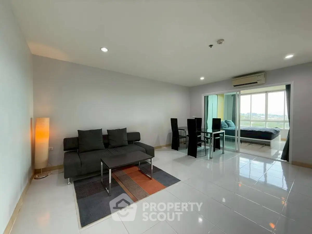Spacious modern living room with sleek furniture and large windows offering a stunning view.