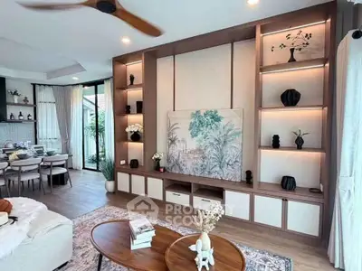 Elegant living room with modern decor and open layout, featuring stylish shelving and cozy seating area.