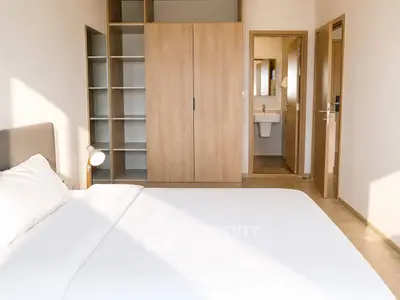 Spacious bedroom with modern design and ensuite bathroom, featuring ample storage and natural light.