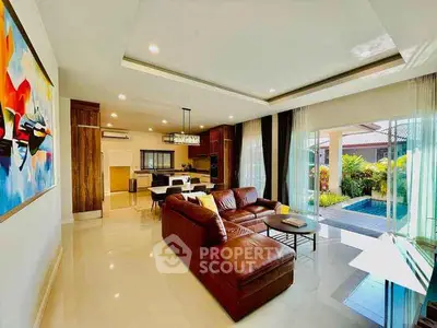 Luxurious open-plan living room with leather sofa and pool view, perfect for modern living.