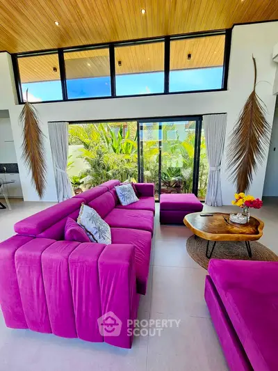 Luxurious living room with vibrant purple sofas and tropical garden view, perfect for relaxation and entertaining.