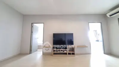 Spacious living room with modern TV setup and minimalist design