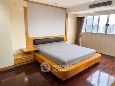 Spacious bedroom with city view and modern wooden furniture