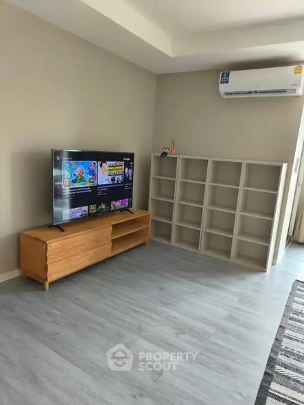 Modern living room with sleek TV setup and stylish shelving unit.