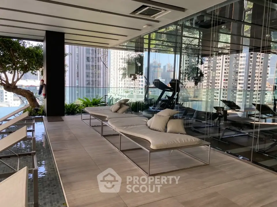 Luxurious gym with city view and modern lounge chairs in high-rise building