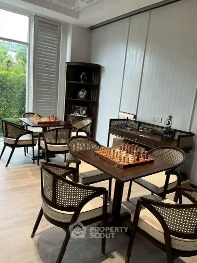 Elegant study room with chess tables and garden view, perfect for intellectual pursuits.