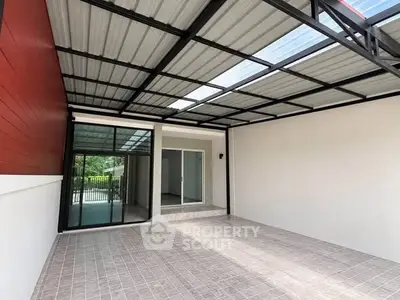 Spacious covered patio with modern roofing and tiled flooring, perfect for outdoor relaxation.