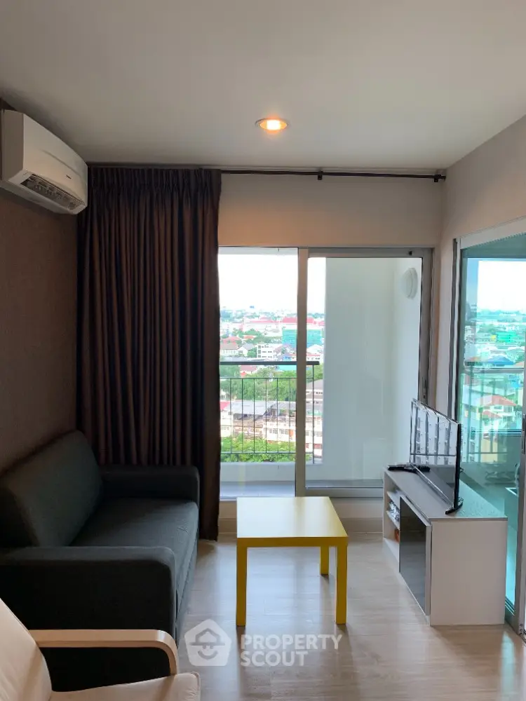 Cozy living room with modern furnishings, ample natural light, and a stunning city view, perfect for urban living.