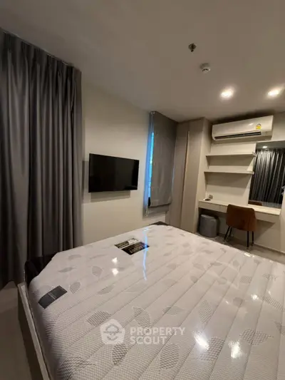 Modern bedroom with sleek design, featuring a wall-mounted TV and stylish furnishings.
