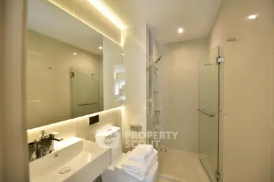 Luxurious modern bathroom with glass shower and elegant lighting