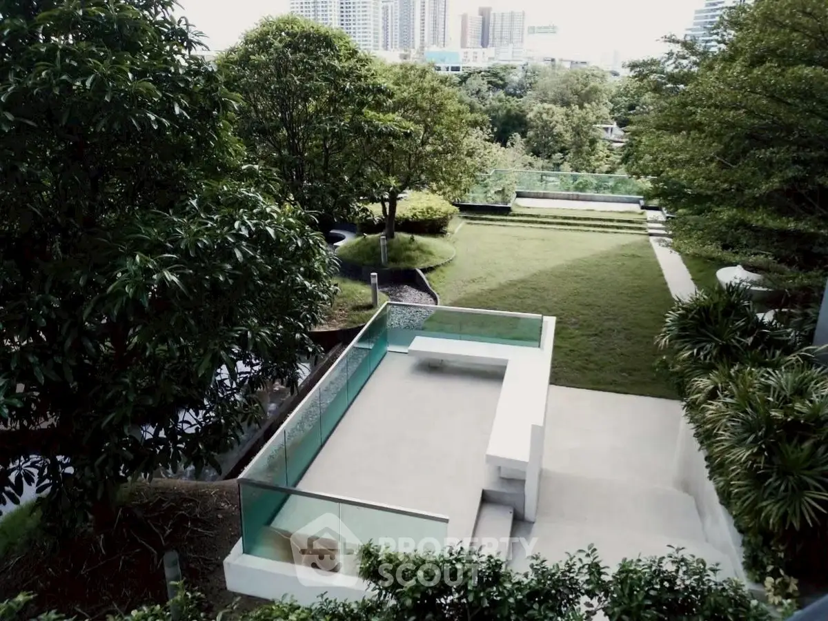 Luxurious garden view with modern outdoor seating and lush greenery in urban setting.