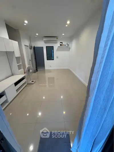 Spacious unfurnished room with glossy tiled flooring and air conditioning, perfect for customization.