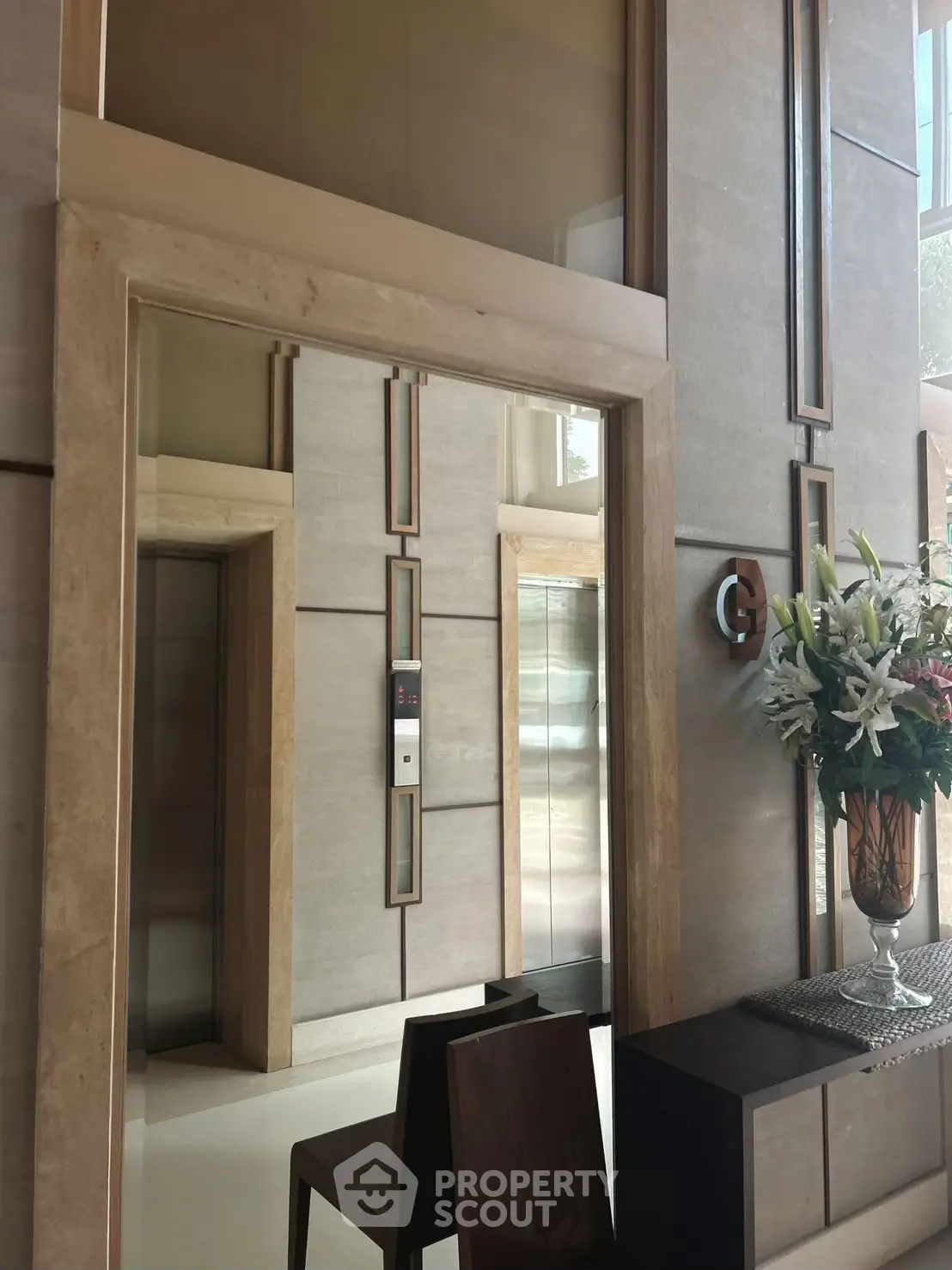 Luxurious building entrance with modern elevator and elegant decor