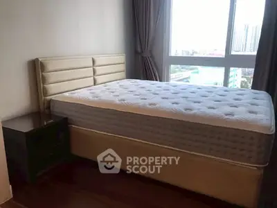 Cozy bedroom with plush bed and city view through large window.