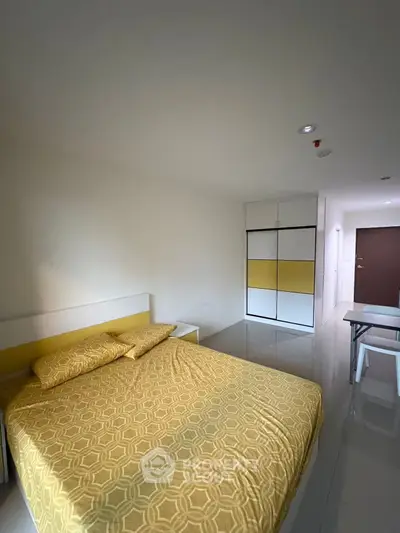 Modern bedroom with yellow accents and sleek furniture in a contemporary apartment.