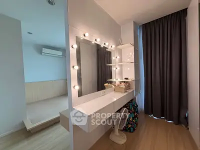Modern bedroom with vanity mirror and stylish lighting, featuring a cozy atmosphere and elegant design.