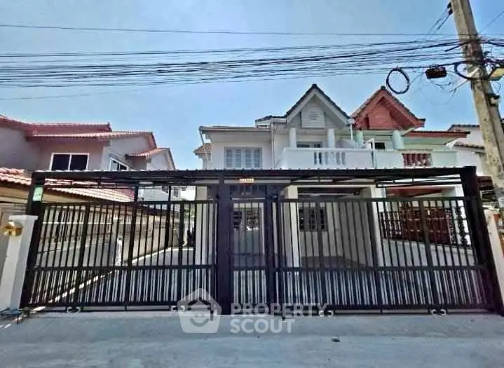 Charming suburban house with gated entrance and modern architecture.
