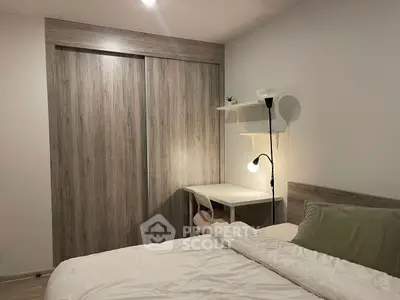 Cozy bedroom with modern wooden closet and study desk, perfect for relaxation and productivity.