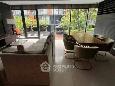 Luxurious living room with modern furniture and garden view through large windows.