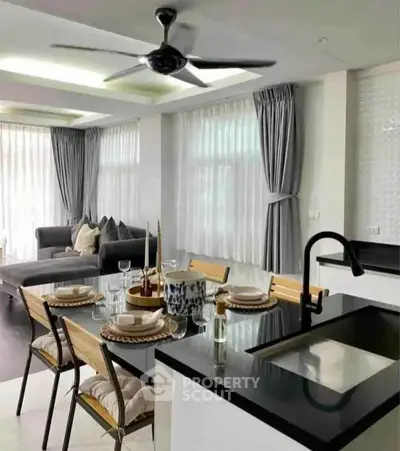 Modern open-layout kitchen and living room with elegant decor and natural light.