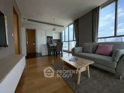 Spacious modern living room with city view, wooden flooring, and cozy furniture in a high-rise apartment.