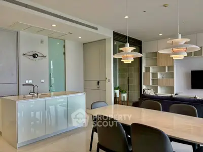 Modern open-plan kitchen and living area with stylish lighting and sleek design.