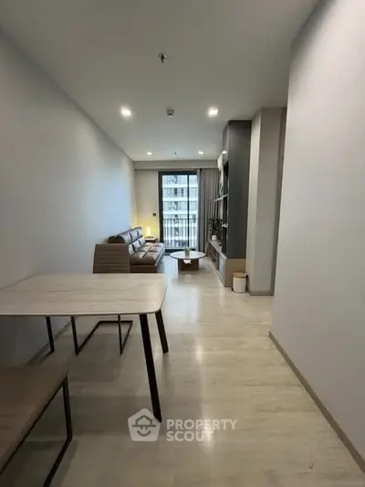 Modern living room with sleek furniture and balcony view in a stylish apartment.