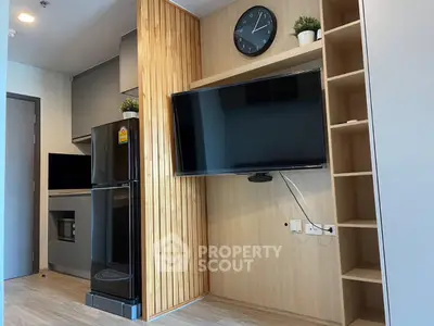 Modern apartment interior with sleek kitchen and wall-mounted TV