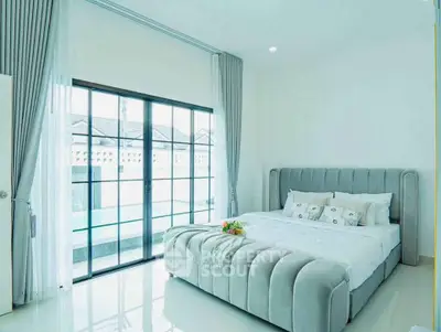 Luxurious bedroom with plush bed and large windows offering ample natural light.